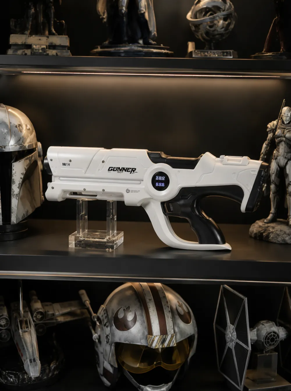 Beam Cannon MK-V displayed on a shelf between other sci-fi collectibles, showing its full 54 cm white body in context — unit at rest, no beam visible